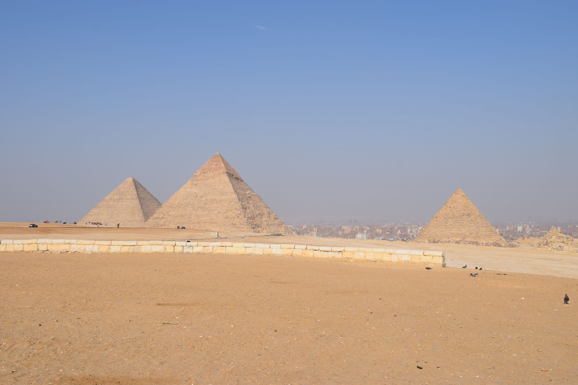 Breathtaking landscape of the Giza Pyramids under a clear blue sky in Cairo, Egypt.