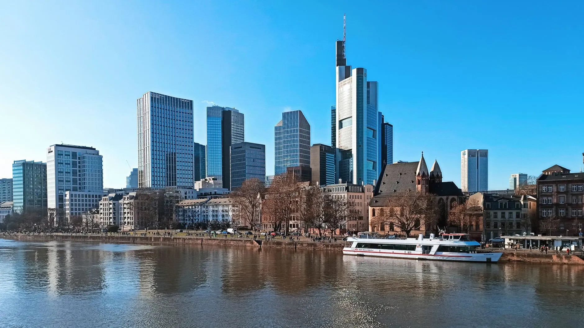 Skyline of Frankfurt, Germany, with skyscrapers and Main River on a clear day.