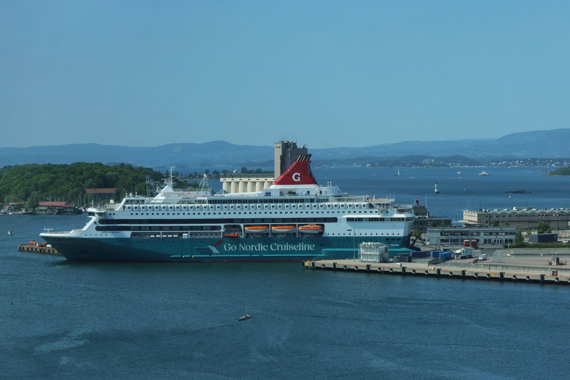 A cruise ship docked at Oslo harbor under a clear blue sky in Norway.