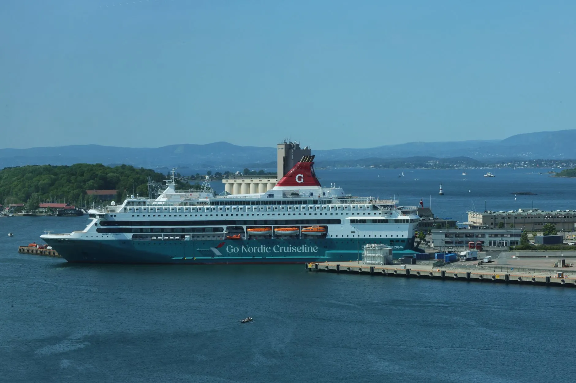 A cruise ship docked at Oslo harbor under a clear blue sky in Norway.