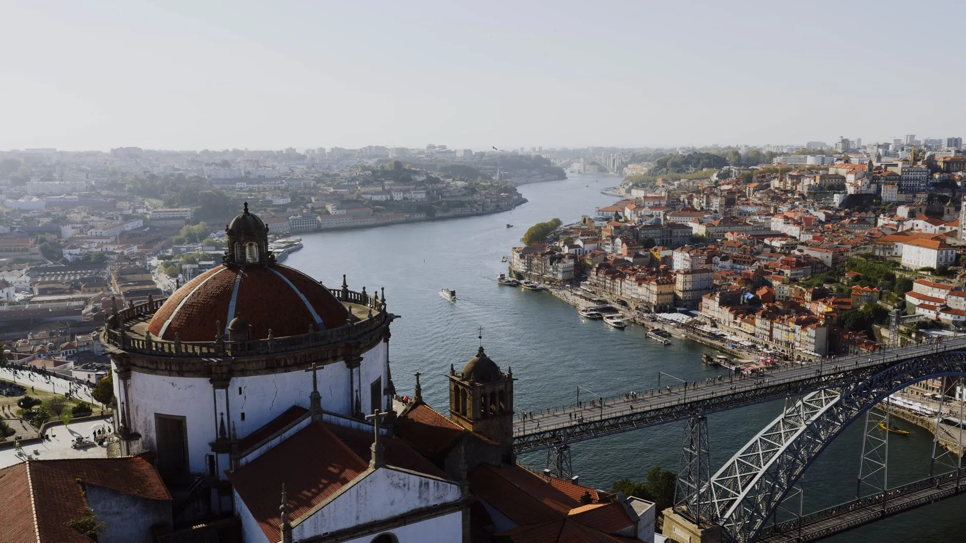Stunning aerial vista of Porto, Portugal with the Douro River and Dom Luís I Bridge on a sunny day.