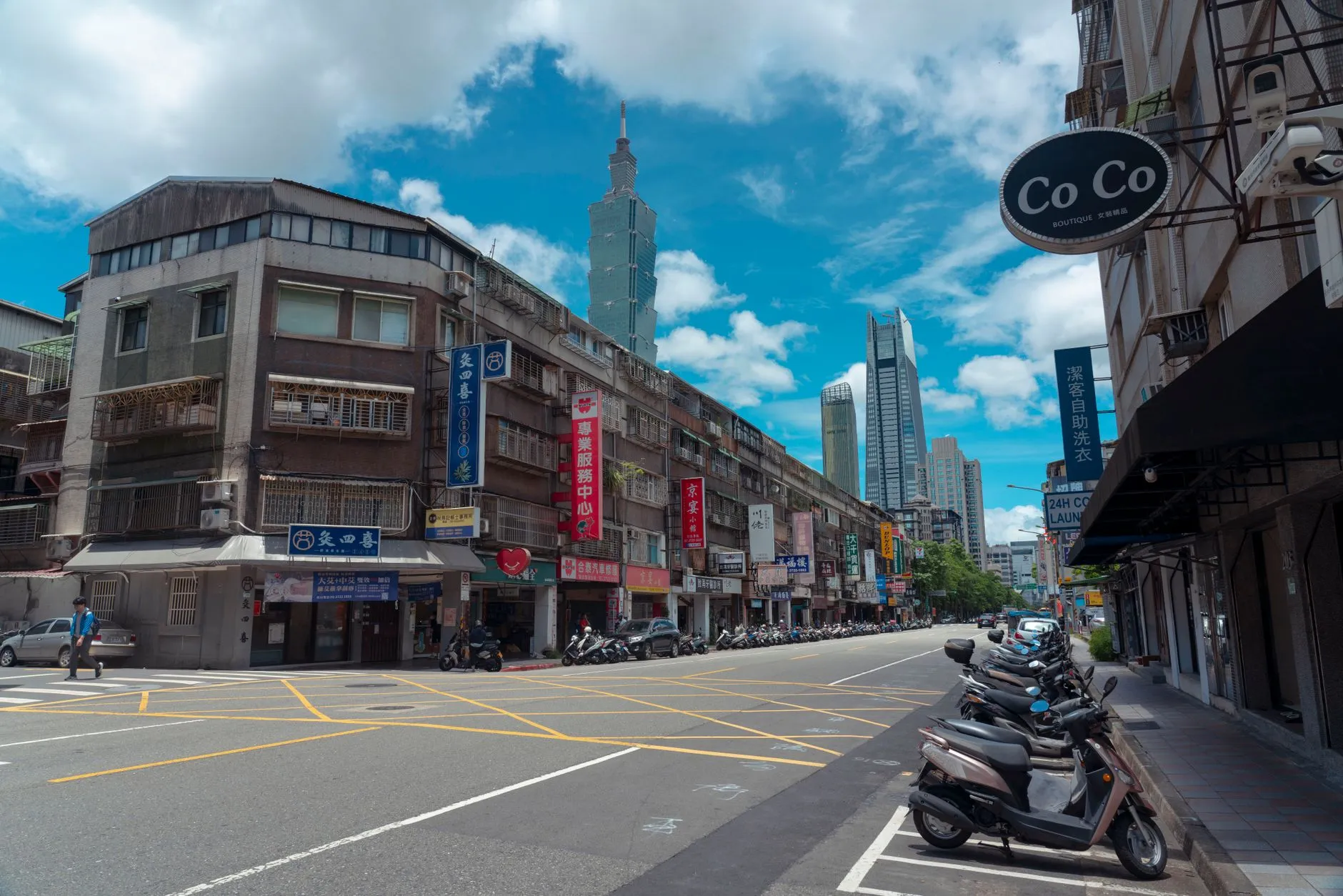 A bustling urban street scene with Taipei 101 and local shops in Taipei, Taiwan.