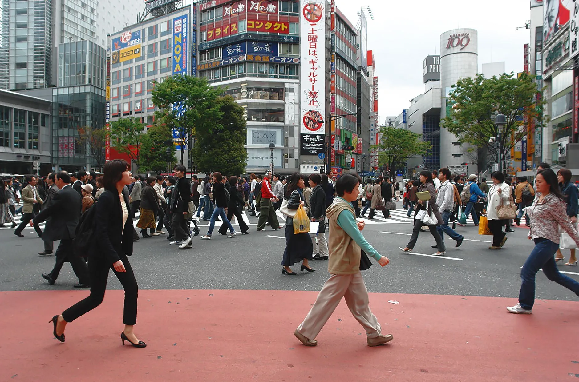 A vibrant scene of people crossing at the iconic Shibuya Crossing in Tokyo, Japan, daytime.
