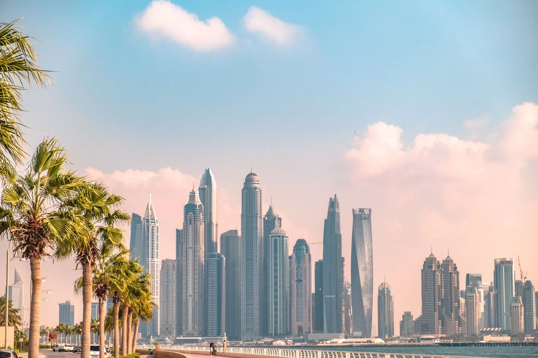 Dubai, UAE — the Marina skyline behind a palm-lined seafront promenade