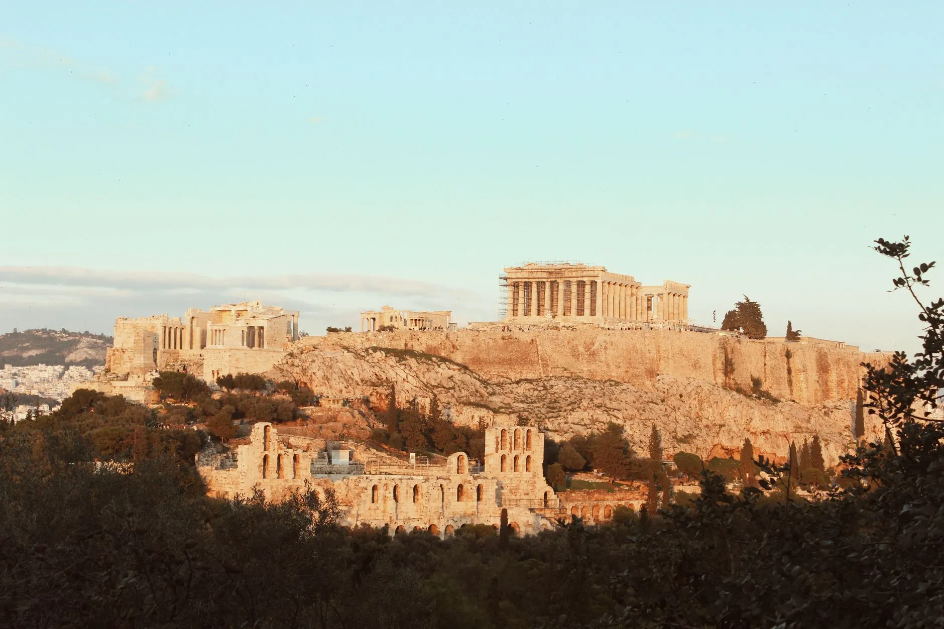The Acropolis of Athens in warm evening light, ancient ruins on the rock above the city, Athens, Greece