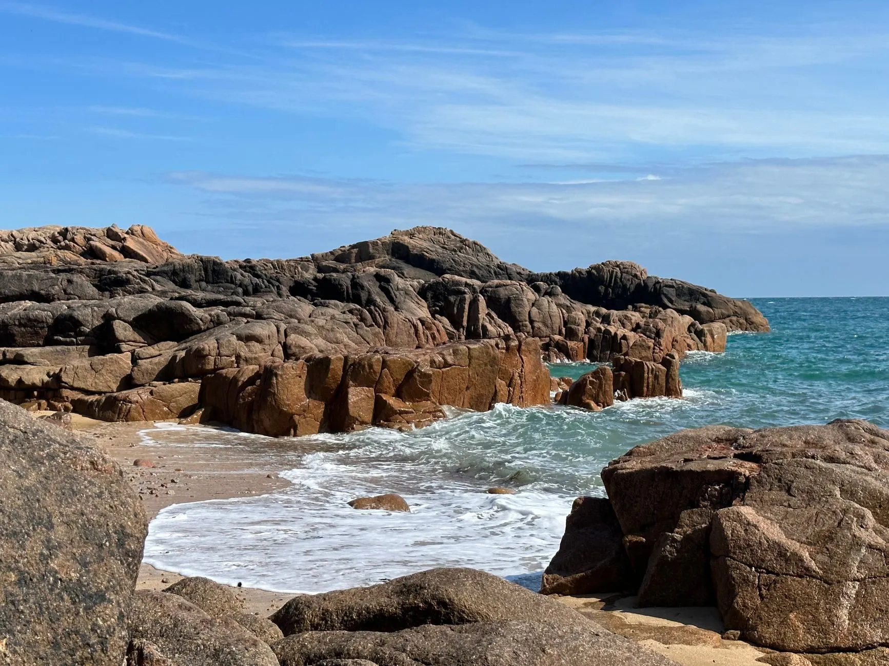 Jersey, Channel Islands — Scenic view of rocky coastline with waves crashing at Corbiere Point, Jersey. Perfect summer day for travel enthusiasts.
