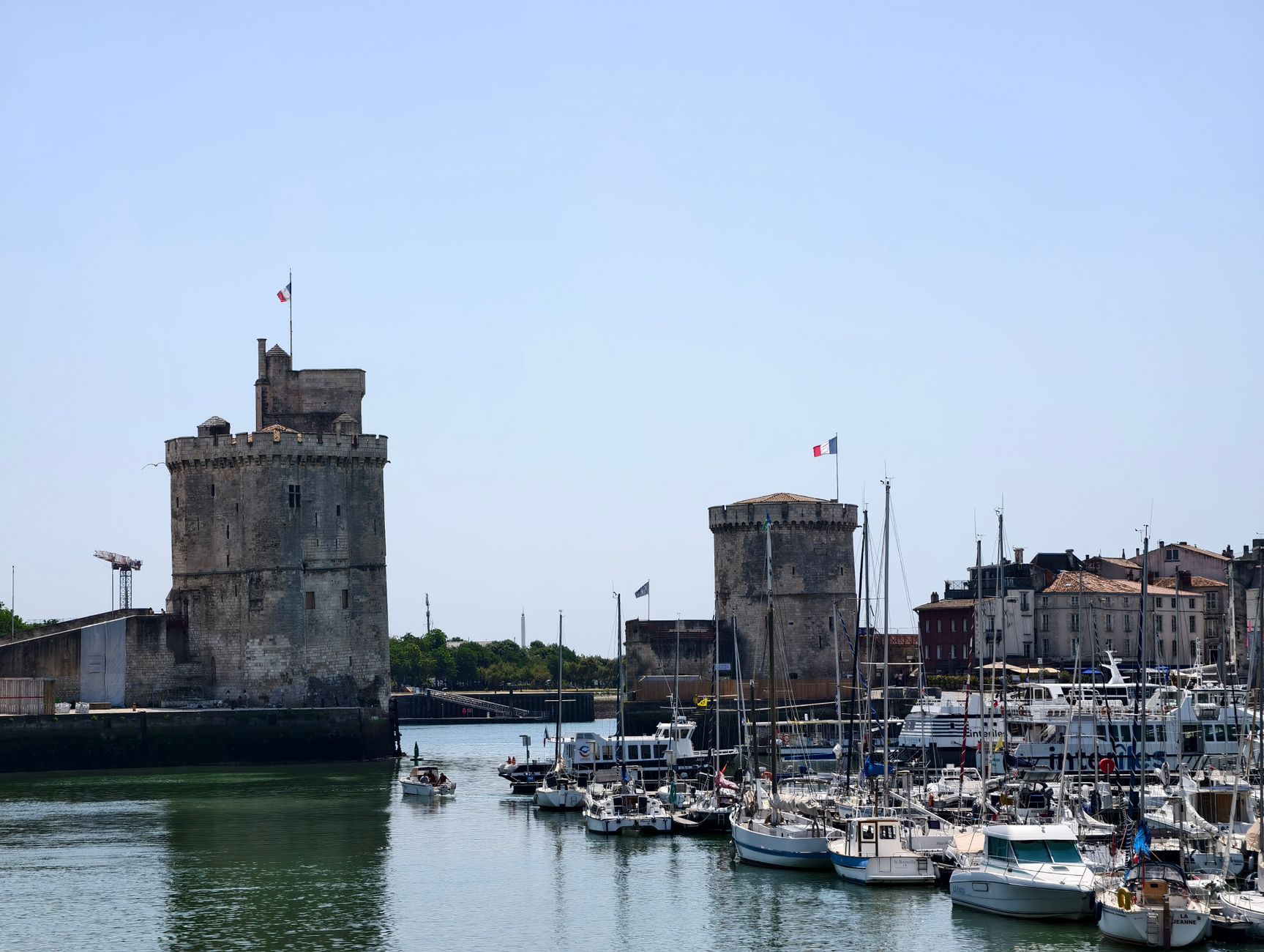 La Rochelle, France — A captivating view of La Rochelle harbor with historic towers and boats under a clear sky.