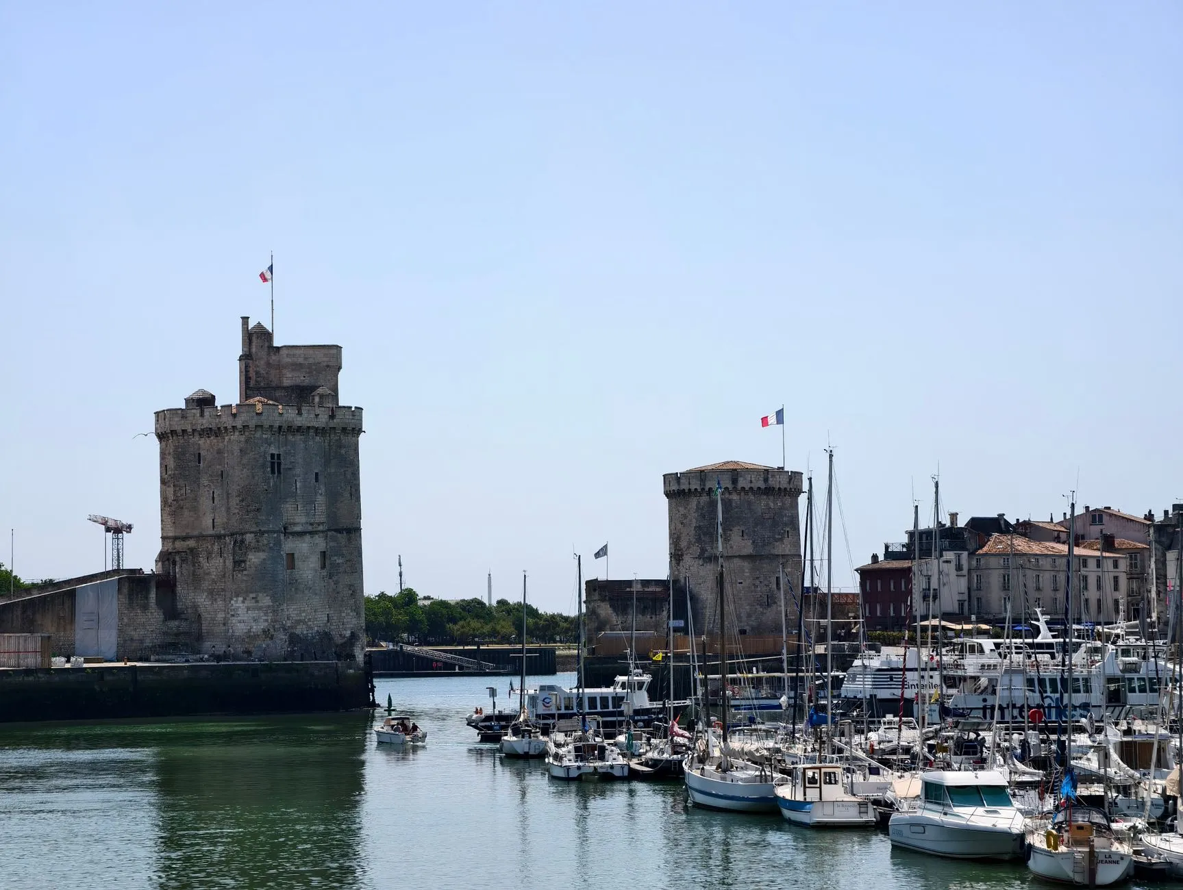 La Rochelle, France — A captivating view of La Rochelle harbor with historic towers and boats under a clear sky.