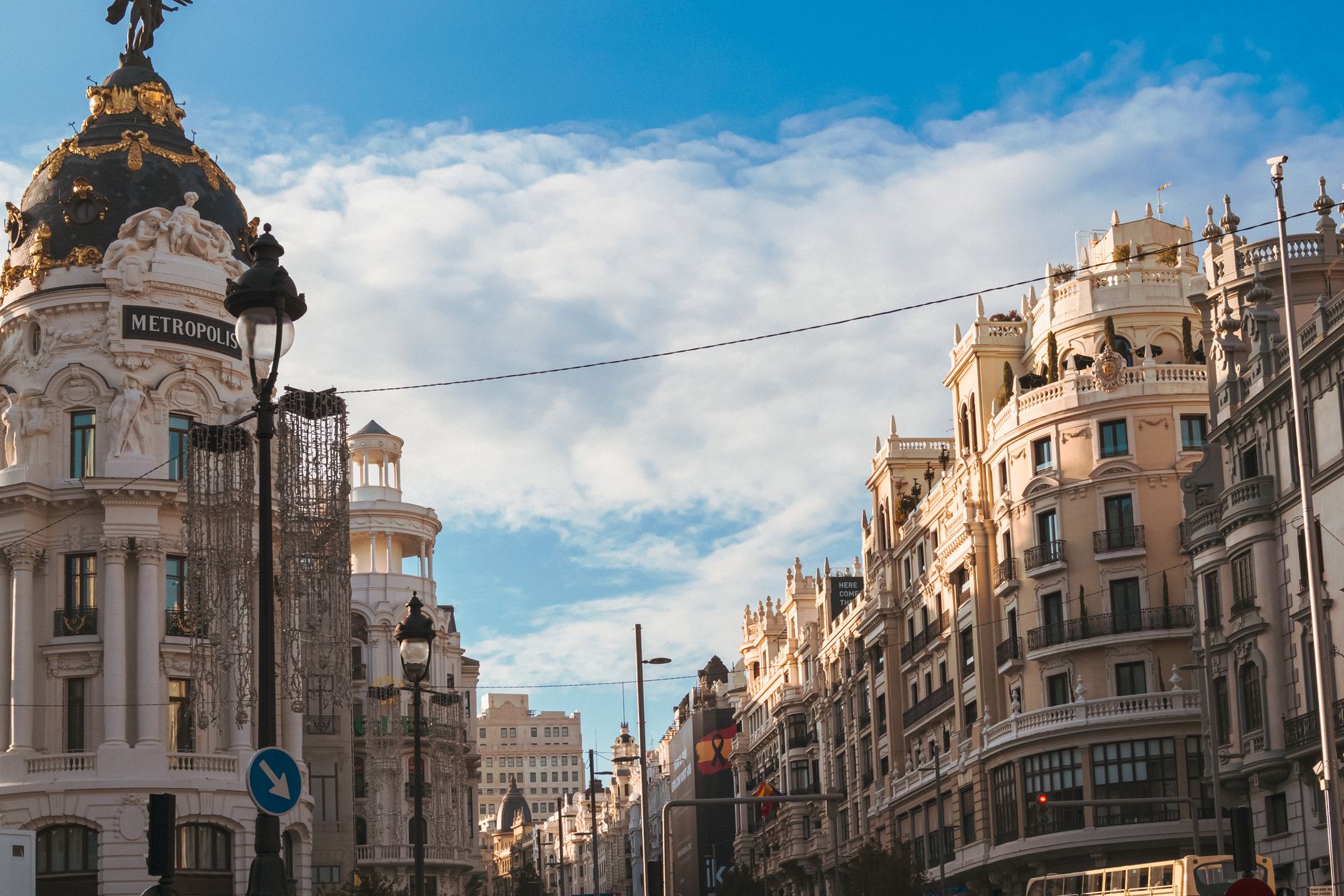 The Metropolis Building and the sweep of Gran Via in central Madrid, Spain, under a bright sky.