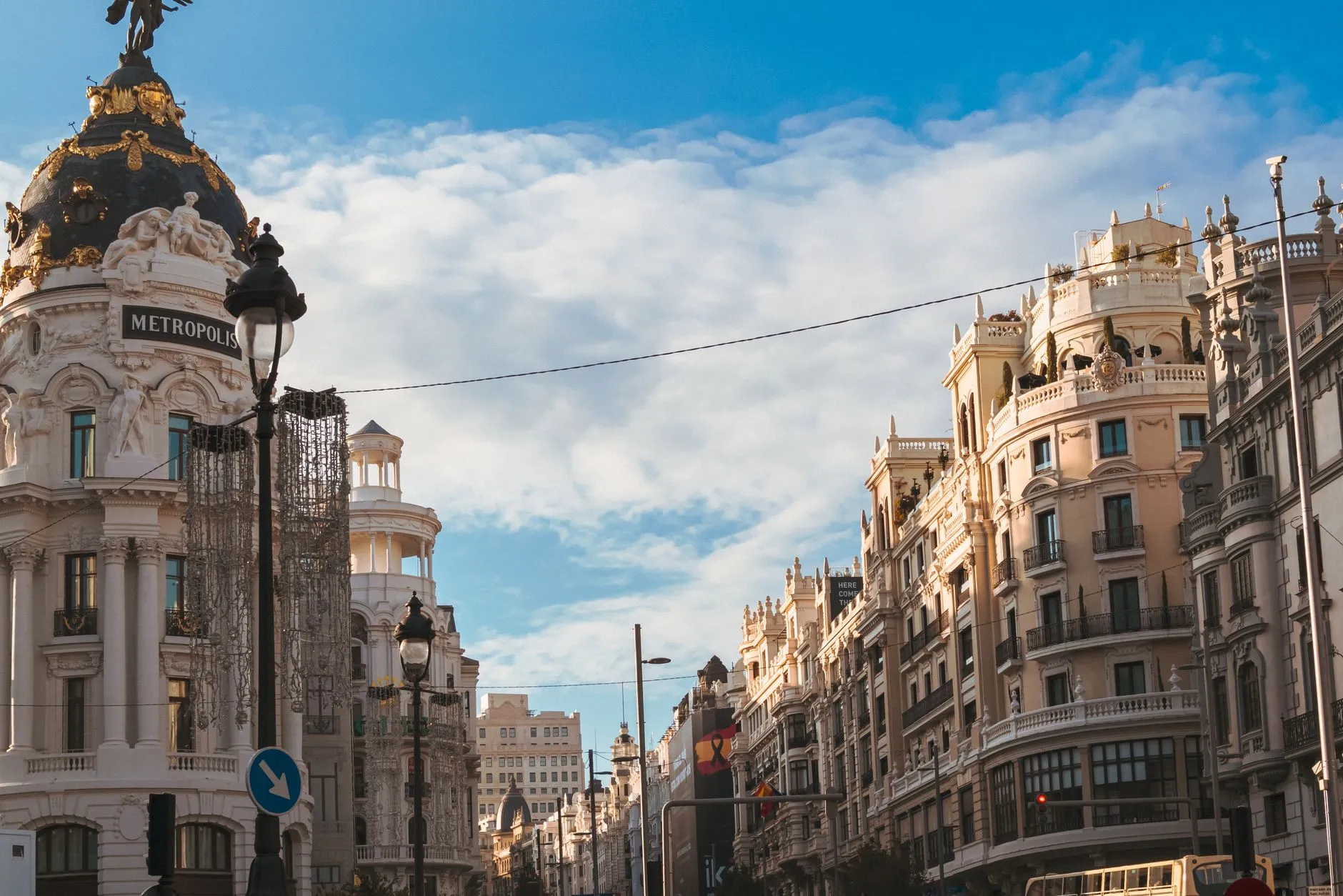 The Metropolis Building and the sweep of Gran Via in central Madrid, Spain, under a bright sky.