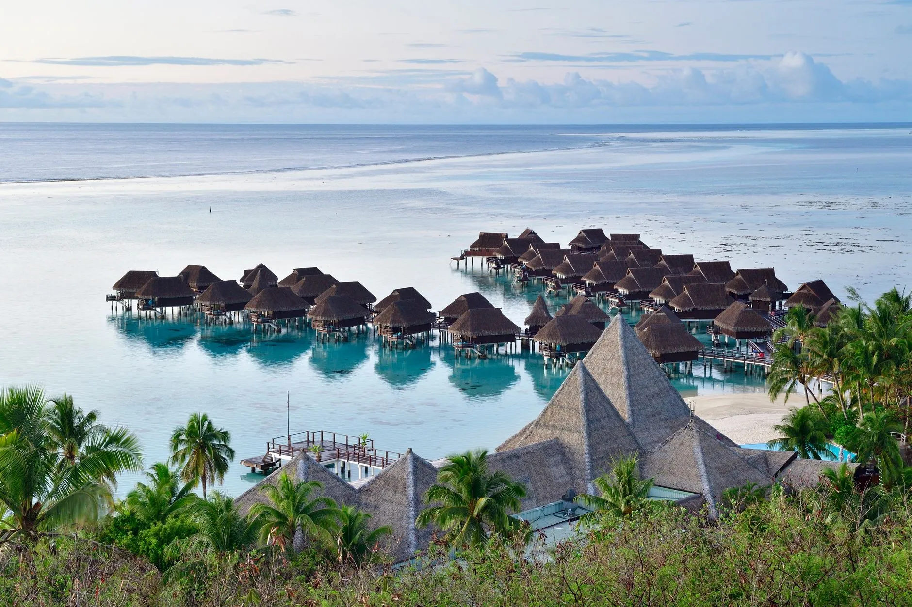 scenic view of overwater bungalows in the tranquil lagoon of moorea, french polynesia.