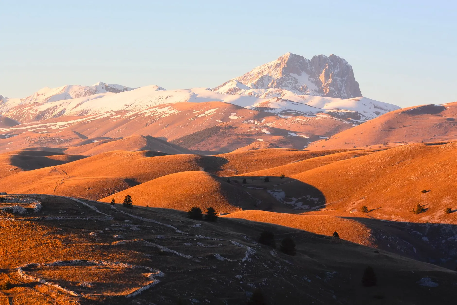 Abruzzo, Italy — Warm sunset light over the snow-capped Gran Sasso mountains in Calascio, Abruzzo, Italy.