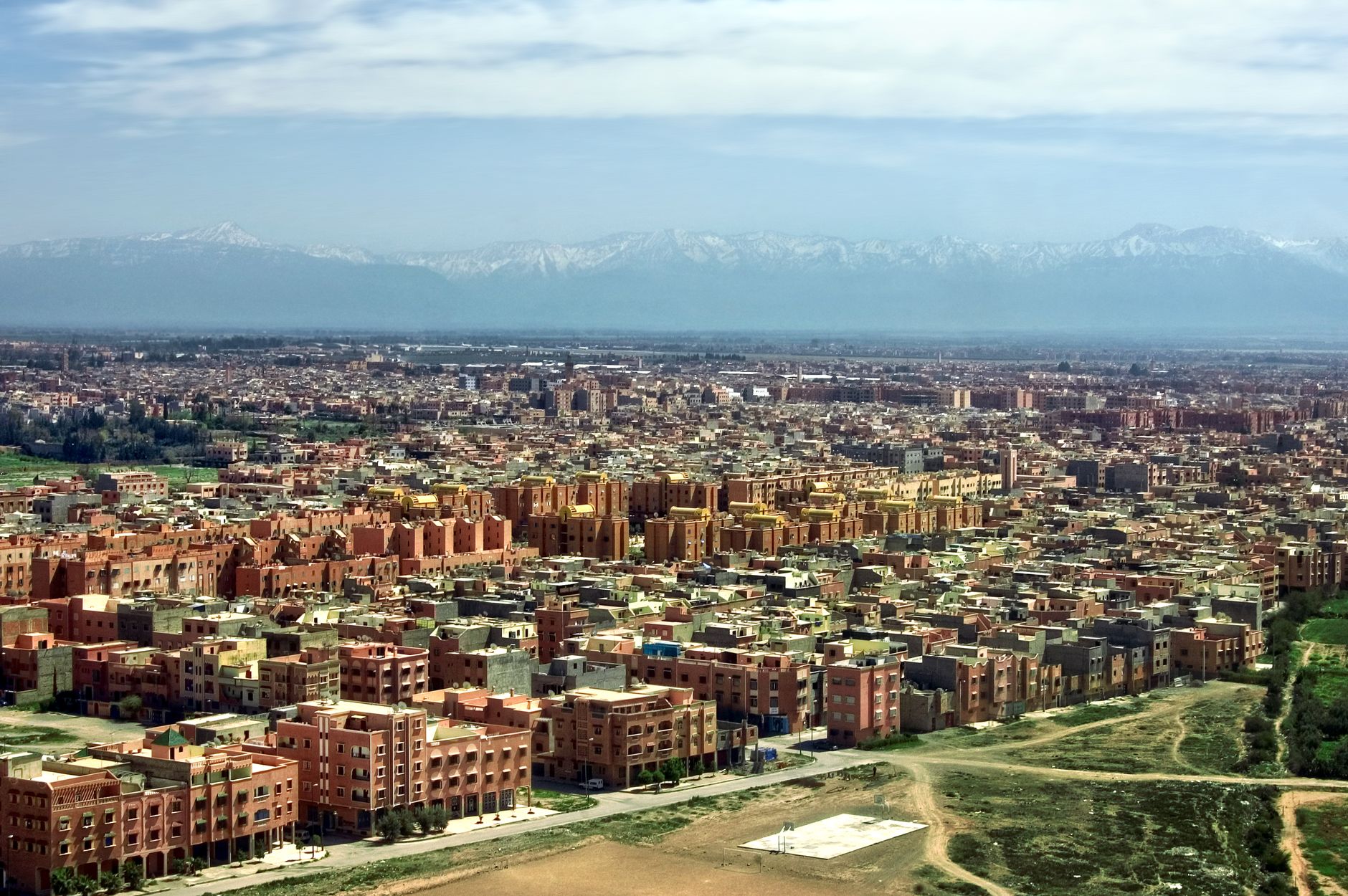The red-walled city of Marrakech spread out below the snow-capped High Atlas Mountains in Morocco.