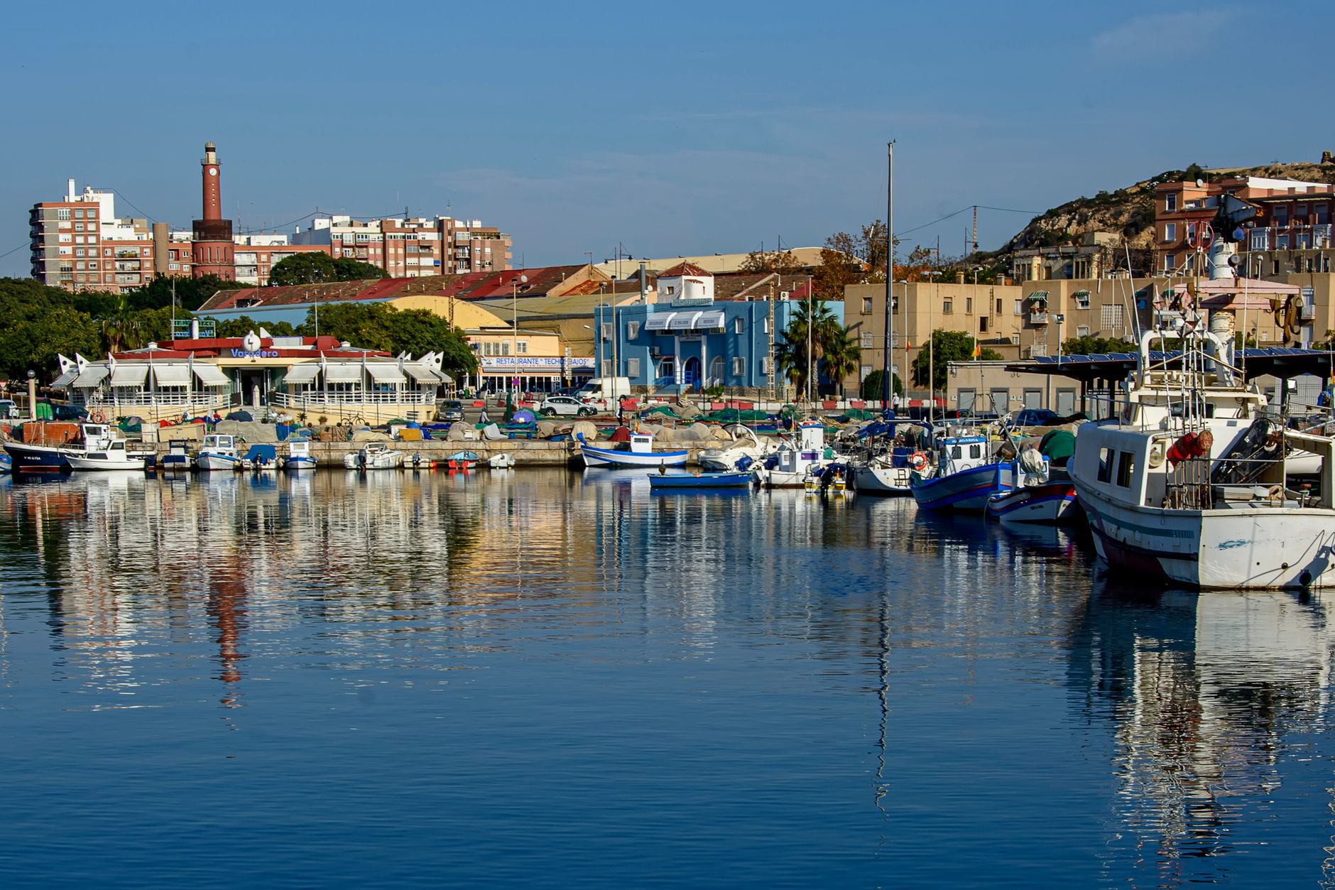 Murcia, Spain — Boats moored in a picturesque harbor in Cartagena, Murcia, with vibrant city backdrop.