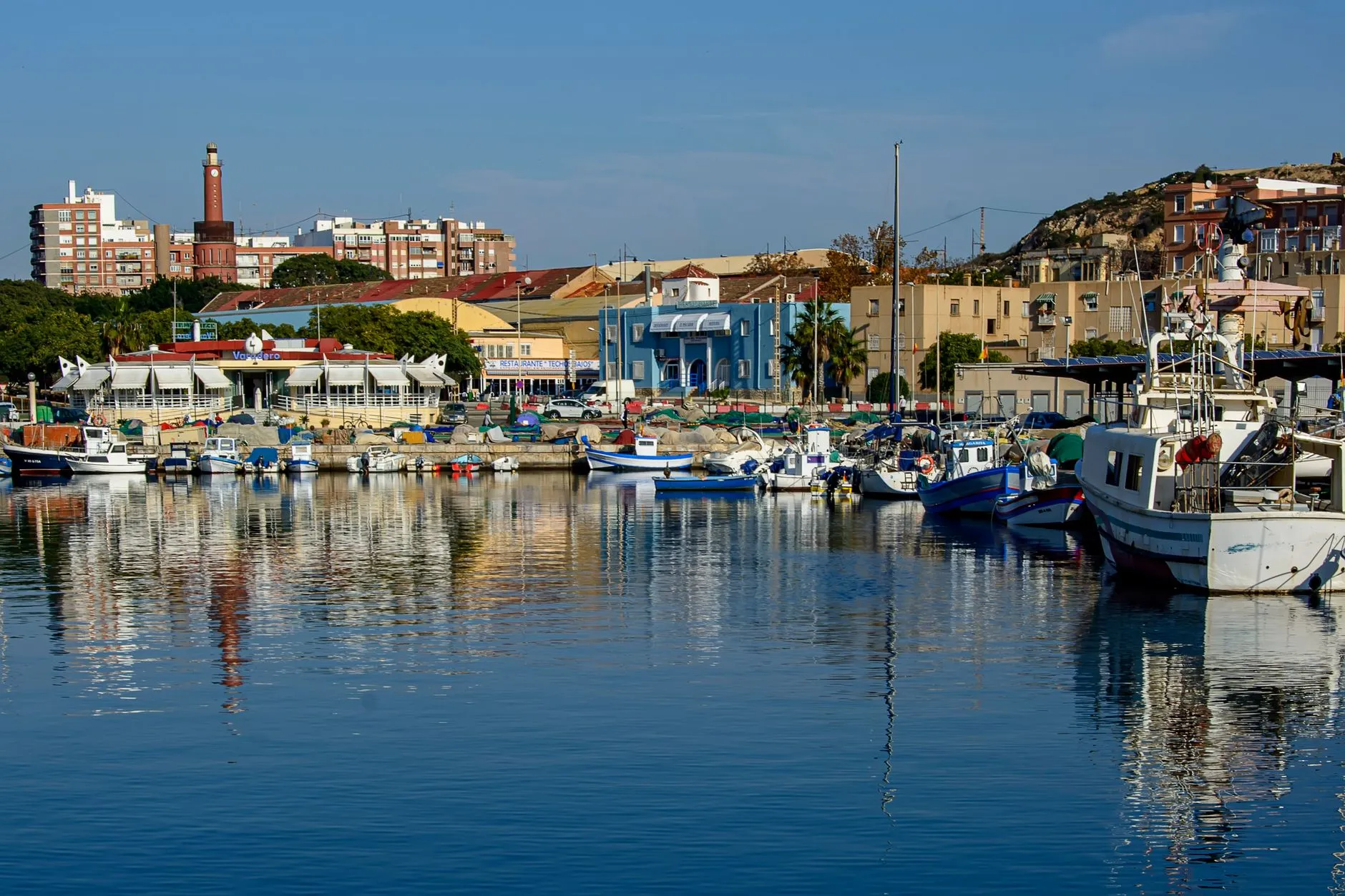 Murcia, Spain — Boats moored in a picturesque harbor in Cartagena, Murcia, with vibrant city backdrop.