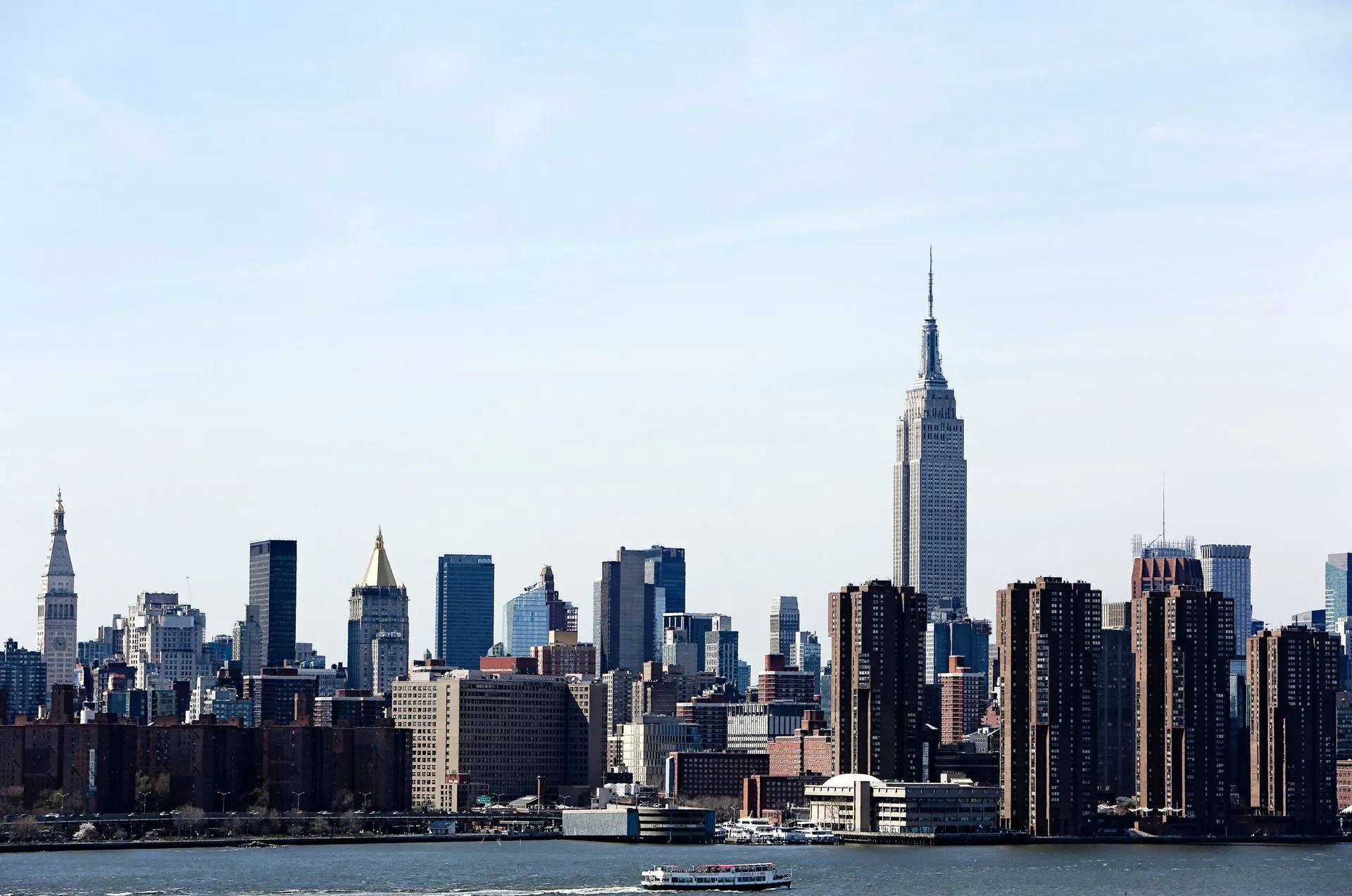 The New York City skyline featuring the Empire State Building under a clear blue sky.
