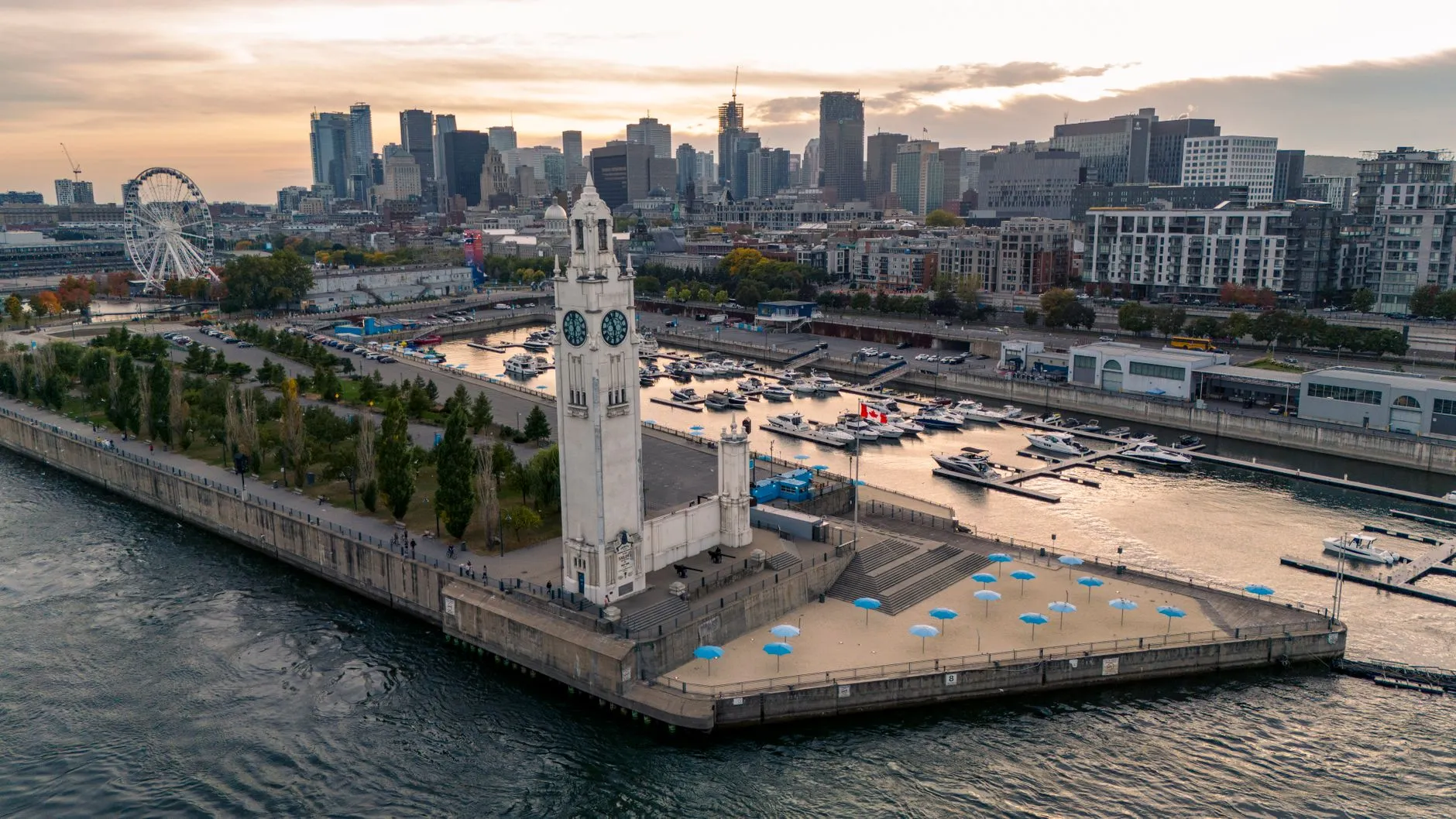 a stunning aerial view of montreal's clock tower beside the waterfront with a vibrant cityscape backdrop.