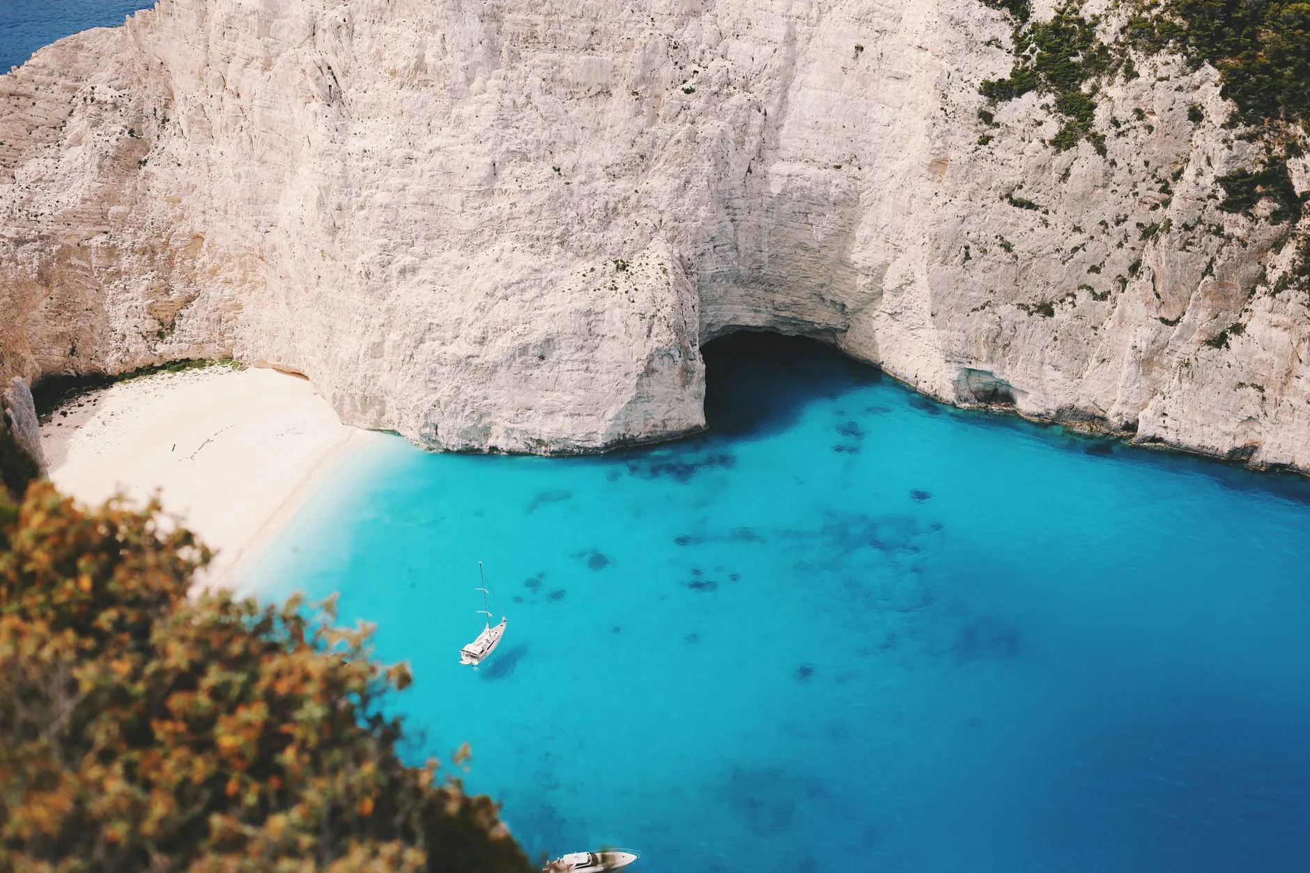 Zakynthos, Greece — A stunning aerial view of Navagio Beach with clear blue waters and steep cliffs in Zakynthos, Greece.