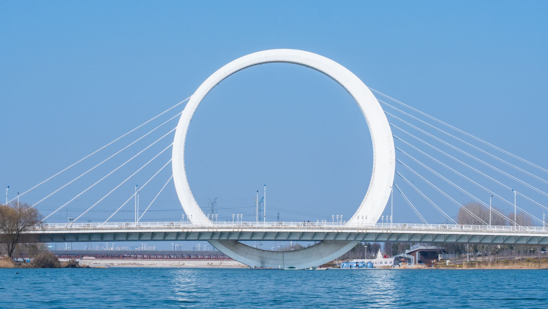 The Infinity Ring Bridge in Zhengzhou, China, under a clear blue sky