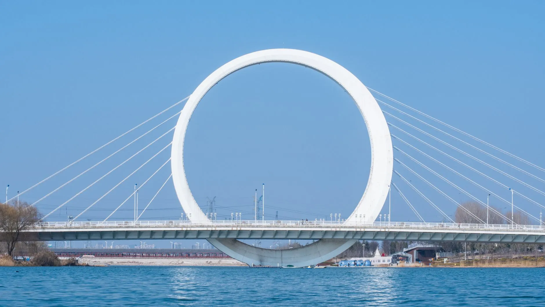 The Infinity Ring Bridge in Zhengzhou, China, under a clear blue sky