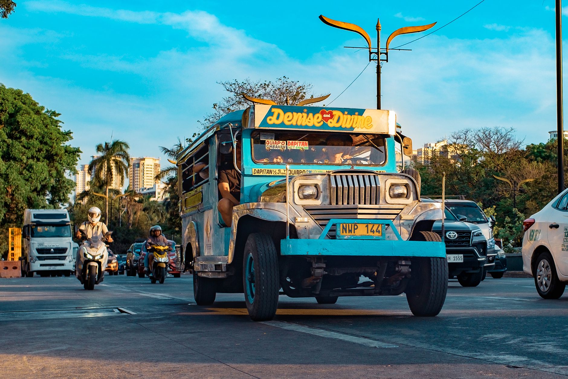Manila, Philippines — a colourful jeepney on a city street under a blue sky